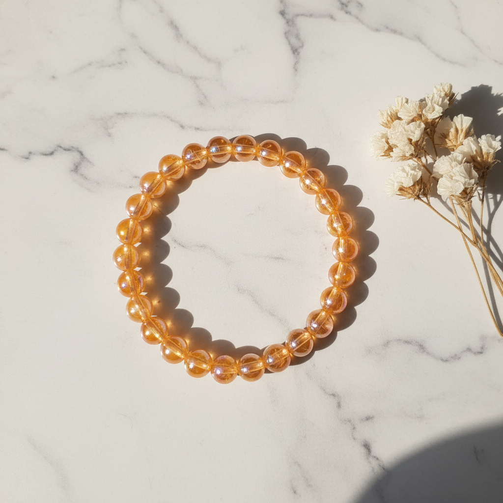 Translucent amber orange aurora iridescent bead stretch bracelet on marble lifestyle background