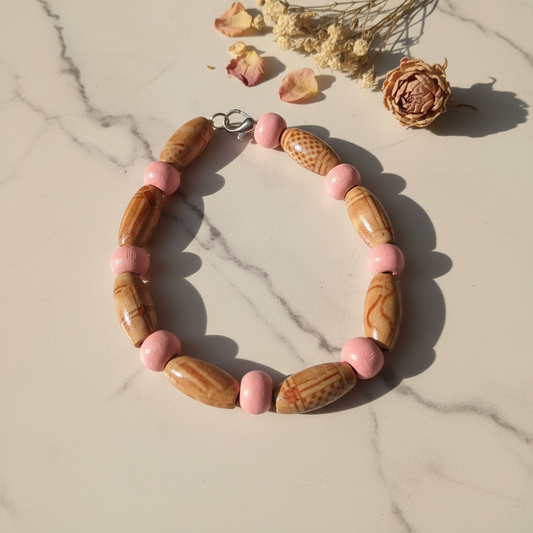 Carved wood barrel and pink ceramic bead bracelet lifestyle