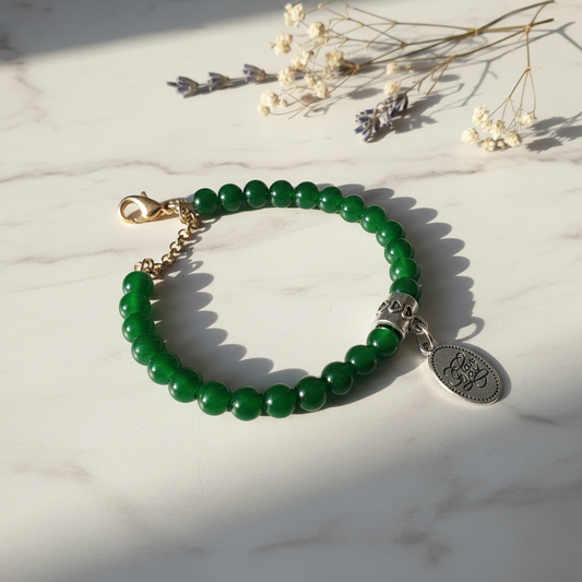 Deep green acrylic bead bracelet with I love you silver charm on marble lifestyle background