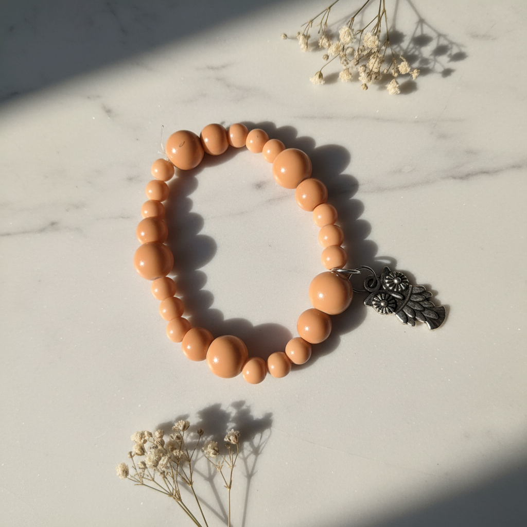 Peach graduated bead bracelet with silver owl charm lifestyle