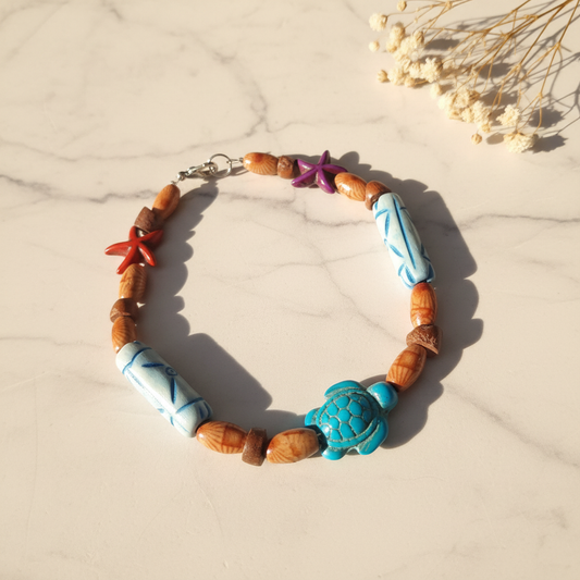 Wood bead bracelet with turquoise sea turtle and starfish on marble lifestyle